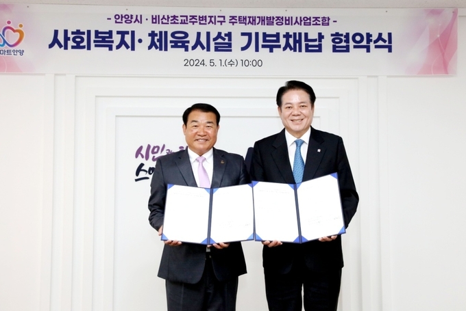 최대호 안양시장(오른쪽)과 정복수 비산초교주변지구 주택재개발정비사업조합장이 1일 협약을 마친 뒤 협약서를 들어보이고 있다. (사진=안양시 제공)