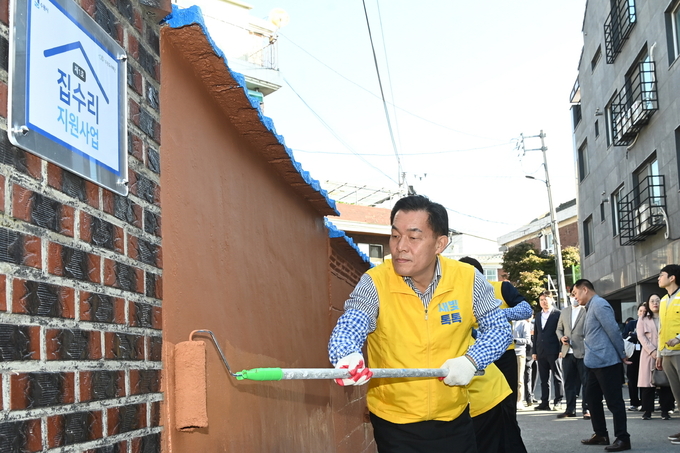 지난해 10월 진행된 수원형 저층주거지 집수리 지원사업 1호 기념식에서 이재준 수원시장이 페인트를 칠하고 있는 모습. (사진=수원시 제공)