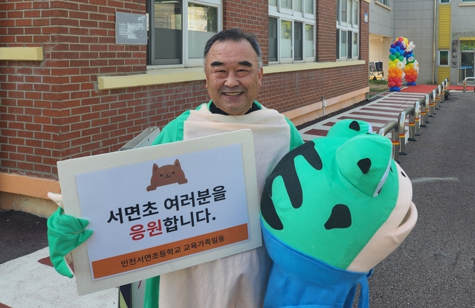 인천 서면초 앞에서 김창용 교장이 학생들 등교맞이를 마무리하고 사진촬영하고 있다. ( 사진 = 박지현 기자 )