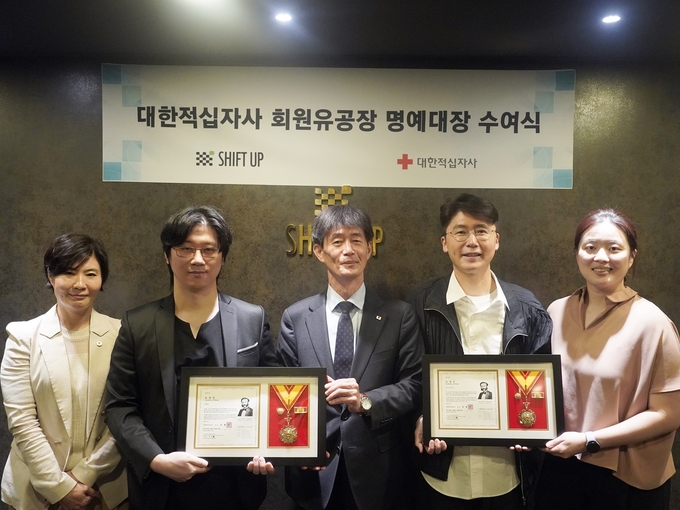 시프트업 김형태 대표(왼쪽에서 두 번째)가 이달 7일에 열린 ‘대한적십자사 회원유공장 전수식’에서 ‘명예대장’을 받고 기념촬영을 하고 있다.(사진=시프트업 제공)