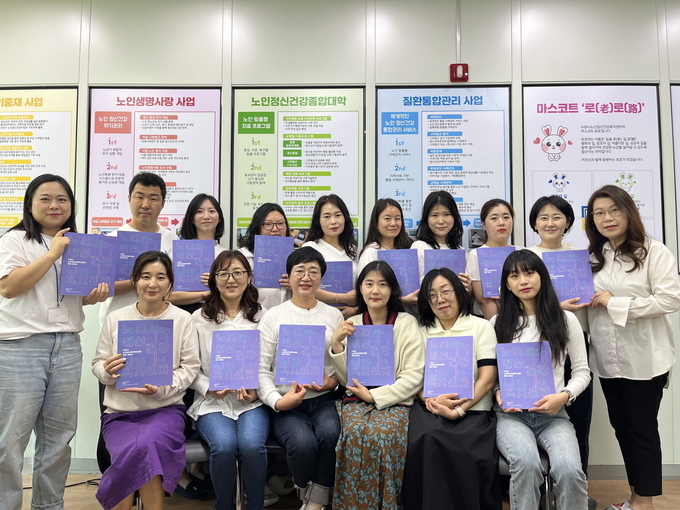 수원시노인정신건강복지센터 관계자들이 ‘노인건강관리 운영 지침서’를 들고 있는 모습. (사진=수원시 제공)