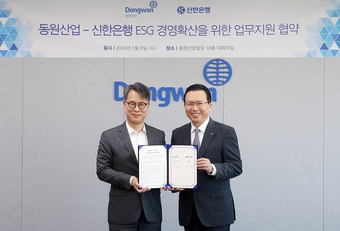 전필환 신한은행 영업추진1그룹장(오른쪽)이 박찬식 동원산업 ESG 운영위원장 상무와 협약식 이후 기념촬영을 하고 있다. (사진=신한은행 제공)