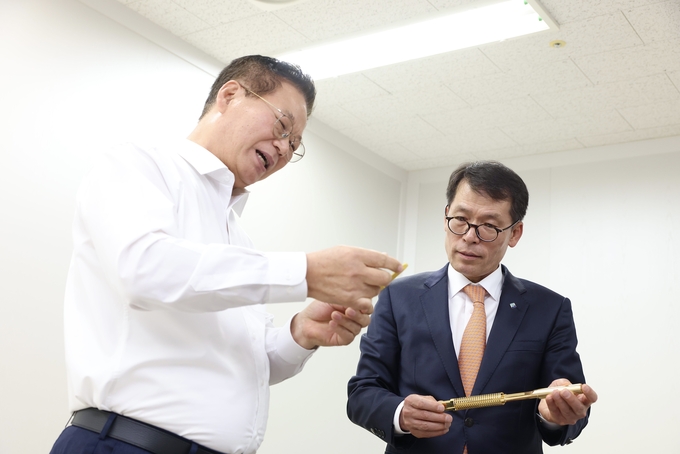 김성태 IBK기업은행장(오른쪽)이 성남산업단지에 소재한 하이콘을 방문해 황동원 대표에게 반도체 테스트 소켓에 대한 설명을 듣고 있다. (사진=IBK기업은행 제공)
