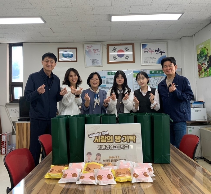 김풍환 평촌경영고 교장과 학생들이 이명아 부림동장(왼쪽 세 번째)에게 단팥빵을 전달한 뒤 기념사진을 찍고 있다. (사진=안양시 제공)