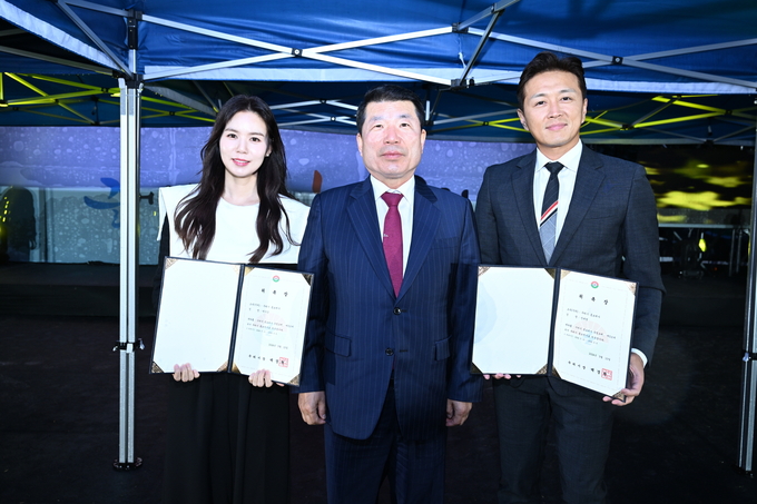 백경현(가운데) 구리시장이 유채꽃 축제 현장에서 시 홍보대사로 새롭게 위촉된 배우 진태현, 박시은 부부와 함께 기념사진을 찍고 있다.(사진=구리시 제공)