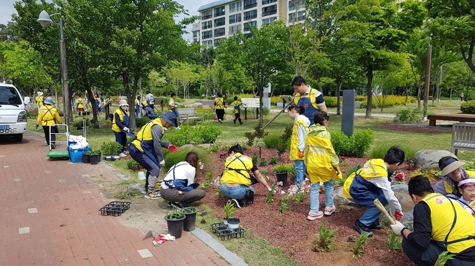 ‘우리동네 손바닥정원 가족봉사단’이 정원을 조성하는 모습. (사진=수원시 제공)