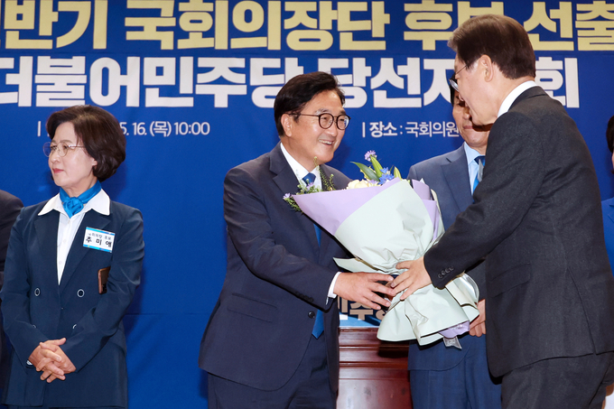 더불어민주당 국회의장 후보로 선출된 우원식 의원이 16일 오전 국회 의원회관에서 열린 제22대 전반기 국회의장단 후보 선출을 위한 당선자 총회에서 이재명 대표로부터 꽃다발을 받고 있다. (사진=연합뉴스) 