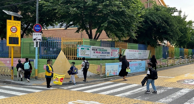 지난 17일 인천 부평남초등학교 정문 근처 이면도로 횡단보도에 있는 연석들이 턱 낮춤되지 않아 학생 등하교와 유모차 통행에 불편을 겪고 있다. ( 사진 = 김주헌 기자 )