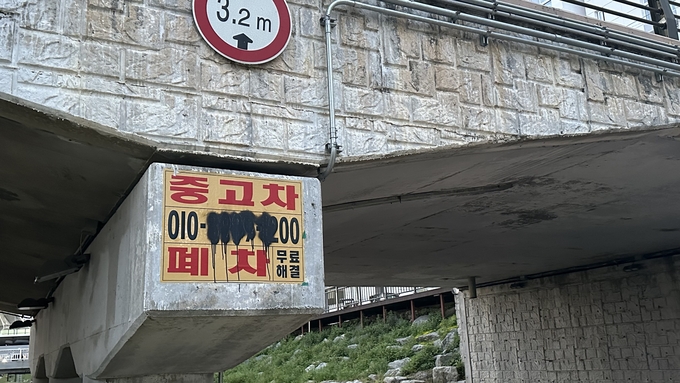 21일 오전 신갈천 생태탐방 산책로에 위치한 교량에 불법 광고물이 부착돼 있다. (사진=박민정 기자)