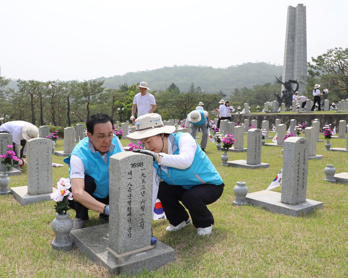 노동진 수협중앙회장(왼쪽)과 강신숙 수협은행장이 제10묘역을 찾아 비석정화, 태극기 꽂기, 헌화 등 묘역 돌봄활동을 펼치고 있다. (사진=Sh수협은행 제공)
