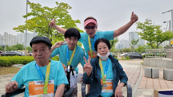 25일 열린 '컬쳐런 2024 인천영종국제도시 마라톤 대회'에 가족런으로 참여한 최고령자 이금자씨(앞줄 오른쪽)가 가족과 함께 완주하고 손가락으로 V자를 만들어 보이고 있다. ( 사진 = 이연수 기자 )