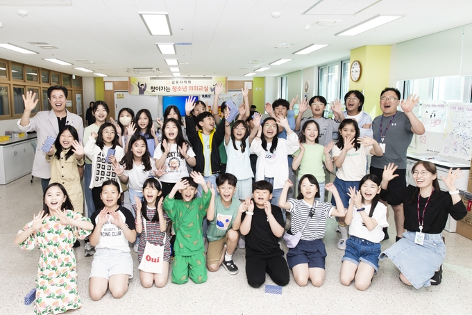 김포보름초등학교에서 열린 청소년 의회교실을 마친 학생들과 의원들의 기념 촬영을 하기 위해 손을 흔들고 있다. (사진=김포시의회 제공)