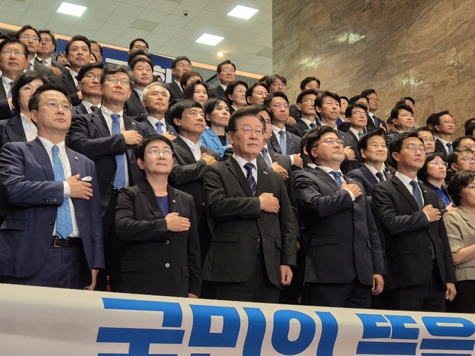 더불어민주당 제22대 국회의원들이 30일 국회 본관 로텐더홀에서 의원총회 시작에 앞서 국기에 대한 경례를 하고 있다. (사진=김한별 기자)