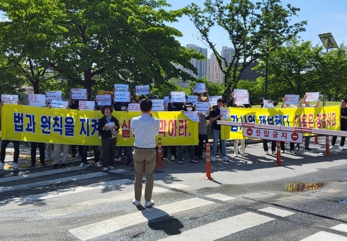 &nbsp;의왕스마트시티 퀀텀 수분양자들이 의왕시청 주차장에서 시공사의 사용승인 신청의 무효를 주장하며 시위를 벌이고 있다. (사진=피해대책연합 제공)