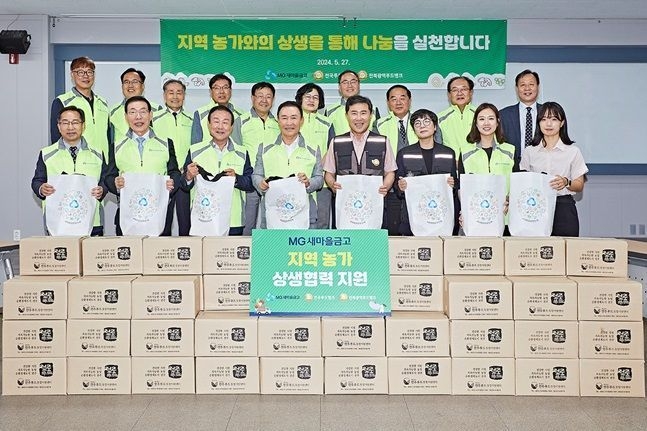 새마을금고중앙회 임직원 및 전북지역 새마을금고 이사장, 한국사회복지협의회 및전북광역푸드뱅크관계자가 MG어글리푸드팩을 들고 기념촬영을 하고 있다. (사진=새마을금고중앙회 제공)