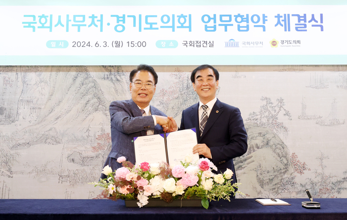 백재현 국회 사무총장과 염종현 경기도의회 의장이 3일 국회접견실에서 열린 ‘국회사무처·경기도의회 업무협약 체결식’에서 업무 협약서를 들고 기념사진을 찍고 있다. (사진=경기도의회 제공)