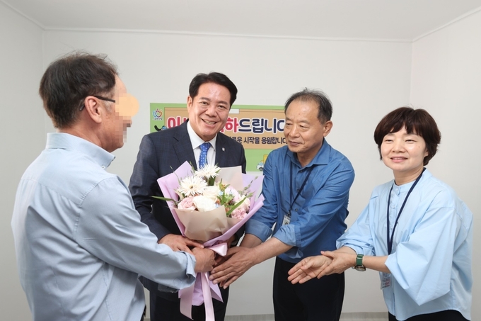 최대호 안양시장(왼쪽 두 번째)이 3일 주거상향지원사업 대상자에게 꽃다발을 전달하며 격려하고 있다. (사진=안양시 제공)