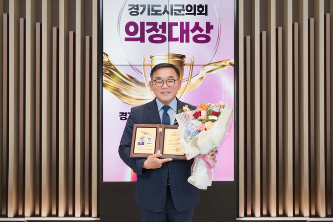 윤원균 용인특례시의회 의장이 경기도시·군의회의장협의회 특별공로패를 들고 기념촬영을 하고 있다. (사진=용인시 제공)