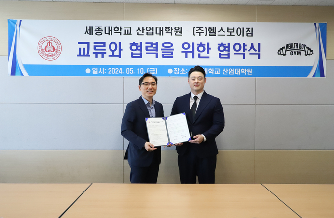 최진호 세종대학교 산업대학원 원장(왼쪽)과 이익표 헬스보이짐 전무이사가 협약서를 들고 기념촬영을 하고 있다. (사진=세종대학교 제공)