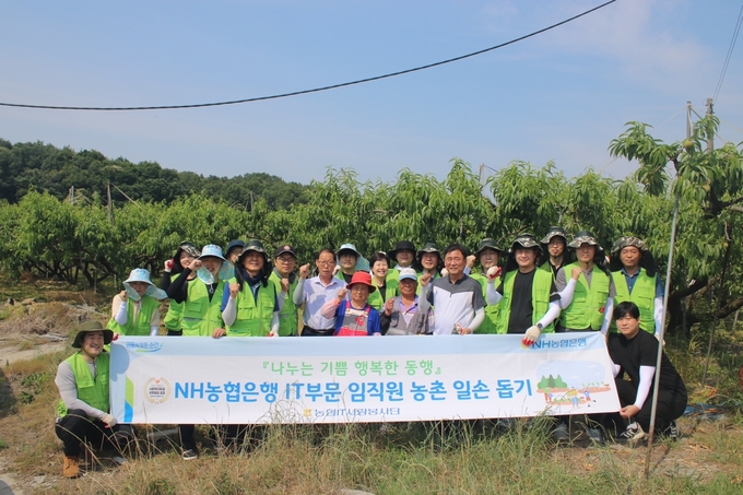 황재현 IT부문 부행장(앞줄 오른쪽 4번째)이 직원들과 함께 일손 돕기 행사후 기념사진을 촬영하고 있다. (사진=NH농협은행 제공)