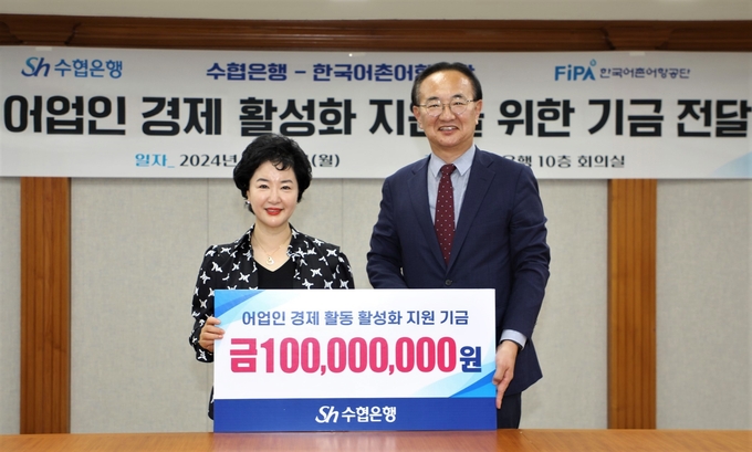 강신숙 수협은행장(왼쪽)이 박경철 한국어촌어항공단 이사장과 기금 전달 후 기념촬영을 하고 있다. (사진=Sh수협은행 제공)