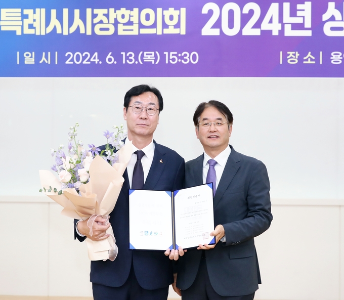 정명근 화성시장(사진왼쪽)이 13일 용인산림교육센터에서 열린 대한민국특례시시장협의회 상반기 정기회의에서 특례시 준회원증을 공식 전달받앗다(사진제공/ 화성시)