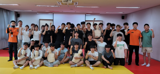 안양대 강화캠퍼스 체육학과 학생들이 강화레포츠파크에서 열린 연계 교육에서 심폐소생술 교육 등을 받은 뒤 인천강화소방서 소방관과 함께 기념촬영을 하고 있다.(사진=안양대 제공)