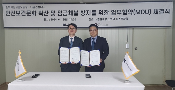 지난 18일 ‘e편한세상 도원역 퍼스트하임’ 신축공사 현장에서 진행된 ‘안전문화 확산 및 건설근로자 임금체불 방지를 위한 업무 협약(MOU) 체결식’ 후 민길수 고용노동부 중부지방고용노동청장(왼쪽)과 이동근 DL건설 CSO가 기념 촬영하고 있다. (사진=DL건설 제공)