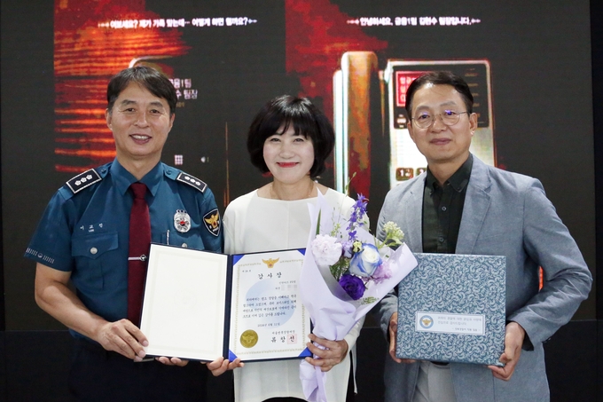 이교진 성북경찰서 범죄예방대응과 과장(왼쪽)과 신한카드 FD팀 직원이 기념촬영을 하고 있다. (사진=신한카드 제공)