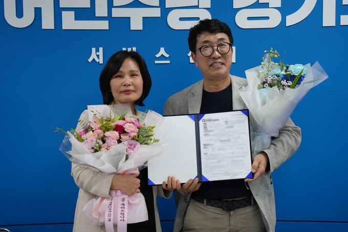 김은경 수원시의회 의원(왼쪽)이 국민의힘을 탈당하고 20일 더불어민주당에 입당했다. 사진은 김 시의원이 더불어민주당 경기도당 당사에서 입당원서를 들고 이재휘 더불어민주당 경기도당 사무처장과 기념사진을 찍는 모습. (사진=민주당 경기도당 제공)