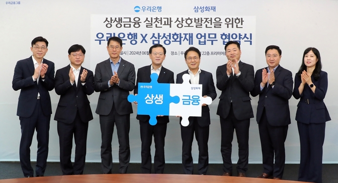 (왼쪽부터) 박용성 우리은행 미래고객전담추진ACT장, 성병용 우리은행 상생금융부장, 김범석 우리은행 국내영업부문장, 조병규 우리은행장, 이문화 삼성화재 사장, 고기호 삼성화재 디지털본부장, 김태윤 삼성화재 디지털마케팅팀장, 박지현 삼성화재 디지털장기일반영업부장이 협약식에서 상생금융 퍼즐을 맞추며 기념촬영을 하고 있다. (사진=우리은행 제공)