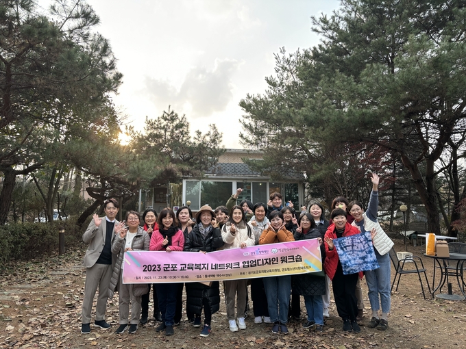 군포 교육복지 유관기관 및 담당자들이 워크숍에 참여해 사진을 찍고 있다. (사진=군포의왕교육지원청 제공)