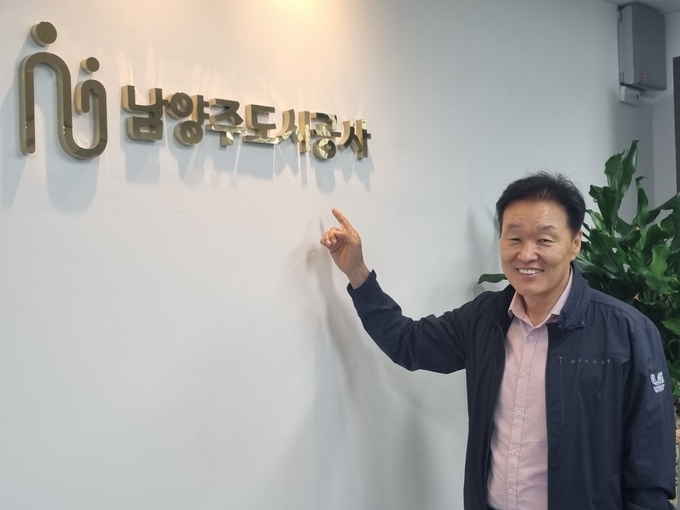 "남양주도시공사를 임기중에 최고의 공사롤 만들겠다"고 밝힌 이계문 사장이 자신있게 공사 로고를 가리키고 있다. (사진=이화우 기자)