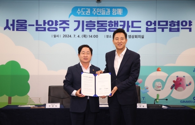 주광덕 남양주시장과 오세훈 서울시장이 체결한 ‘기후동행카드 참여 업무협약서’를 들어보이고 있다. (사진=남양주시 제공)