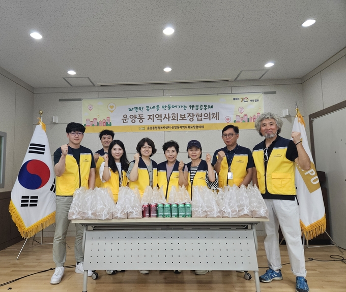 김포시 운양동 지역사회보장협의체 회원들의 취약게층 어른신들에게 사랑의 닭강정 전딜에 앞서 기념사진을 찍고 있다. (사진=김포시 운양동행정복지센터 제공)