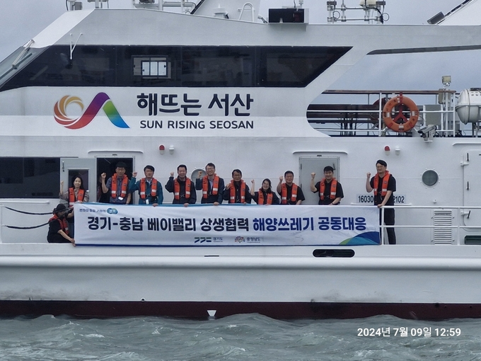 지난 9일 서산 가로림만 인근 해역에서 진행된 해양쓰레기 공동수거 현장에서 경기도와 충청남도 관계자들이 기념촬영을 하고 있다. (사진=경기도 제공)