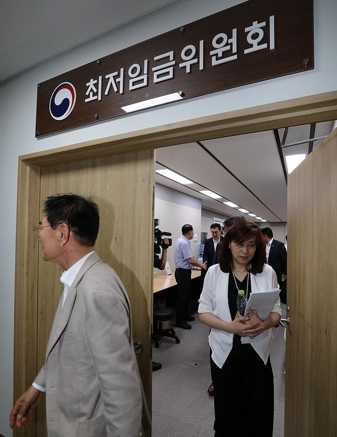 12일 새벽 정부세종청사에서 열린 제11차 전원회의에서 내년 최저임금이 1만 30원으로 결정됐다. 회의가 끝나자 위원들이 회의장을 나서고 있다. (사진=연합뉴스 제공)