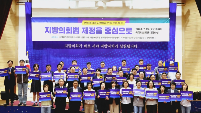 더불어민주당 국회의원과 전국기초·광역의회의원협의회 소속 지방의원들이 지난 13일 국회의원회관 대회의실에서 열린 토론회에서 기념촬영을 하고 있다. (사진=경기도의회 제공)