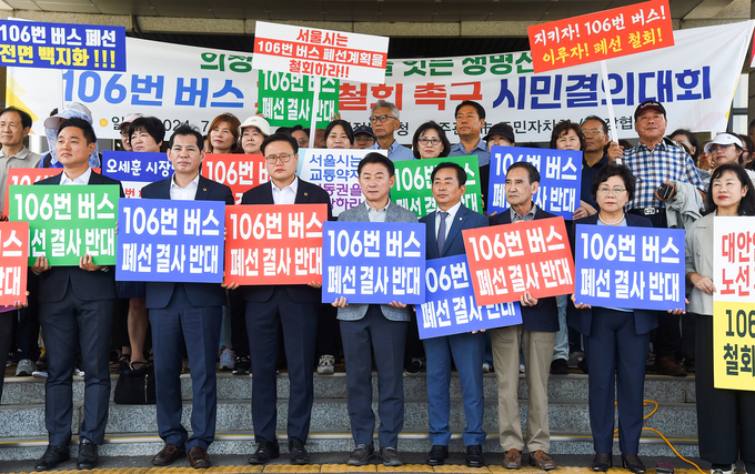 15일 김연균 의정부시의회 의장(왼쪽 4번째)을 비롯한 시의원, 경기도의회 의원, 의정부 시민단체 관계자 등이 의정부시청 본관 앞에서 진행된 서울시 106번 버스 폐선 철회 촉구 시민결의대회에 참여하고 있다. (사진=의정부시 제공)