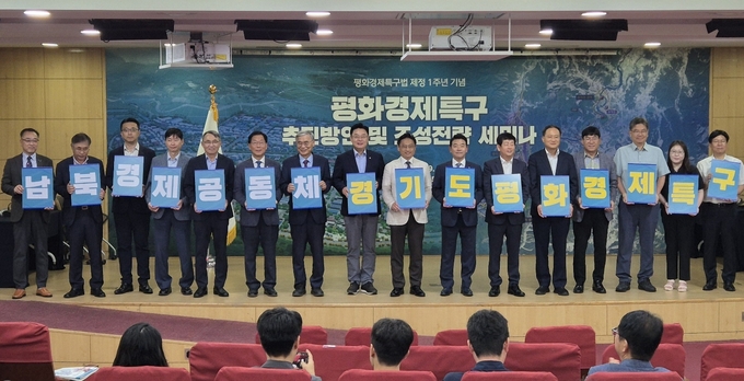 19일 오전 국회 의원회관에서 열린 ‘평화경제특구법 제정 1주년 기념 평화경제특구 추진방안 및 조성전략 세미나’ 참석자들이 팻말을 들고 기념사진을 찍고 있다. (사진=김한별 기자)