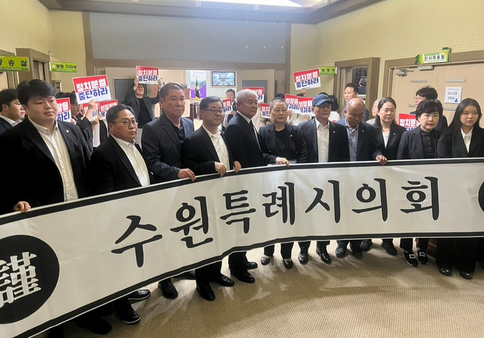22일 수원시의회 제384회 임시회를 앞두고 시의회 더불어민주당과 국민의힘 소속 의원들이 본회의장 앞에서 시위를 벌이는 모습. (사진=장진 기자)