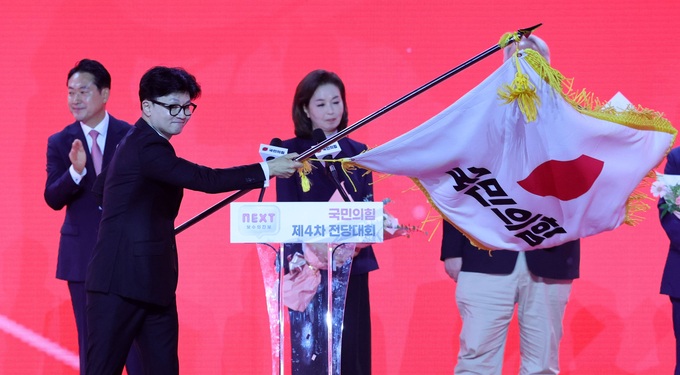 한동훈 신임 당대표가 23일 경기도 고양시 킨텍스에서 열린 국민의힘 제4차 전당대회에서 당기를 흔들고 있다. (사진=연합뉴스)