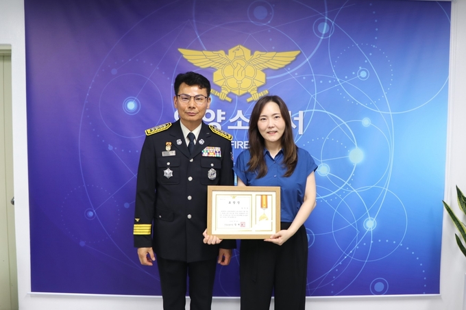장재성 안양소방서장이 24일 화재 피해를 막은 박주연 씨에게 표창장을 수여한 뒤 기념촬영을 하고 있다. (사진=안양소방서 제공)