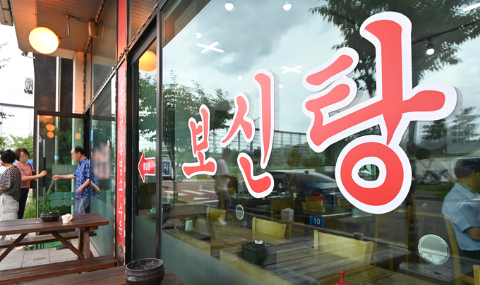 올해 초 '개고기 식용 금지법'이 통과된 이래 첫 중복을 맞은 25일 성남시 모란시장 인근에 위치한 보신탕집에 시민들이 들어가고 있다.