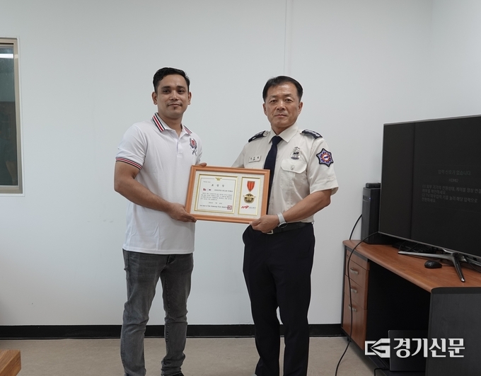 신인철 안성소방서장이 슈레스타 밀란 쿠마르(남, 네팔)씨에게 화재진압 유공 외국인 표창을 수여하고 있다. (사진=안성소방서 제공)