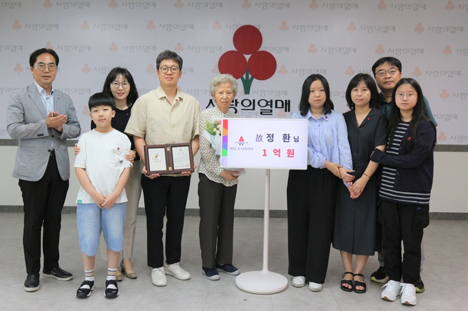 김효진 경기 사랑의열매 사무처장(왼쪽), 故 정환 씨 아내 최병주 씨(왼쪽 다섯 번째)와 가족들의 모습. (사진=경기 사랑의열매 제공)