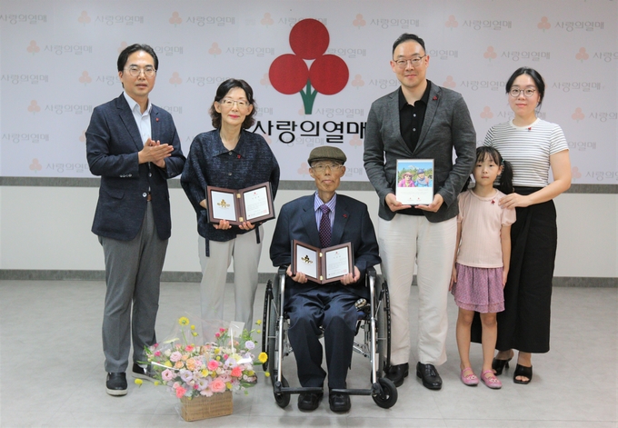 전찬진(가운데)·고희옥(왼쪽 두번째) 부부와 가족들, 김효진 경기 사랑의열매 사무처장(왼쪽)의 기념촬영 모습. (사진=경기 사랑의열매 제공)