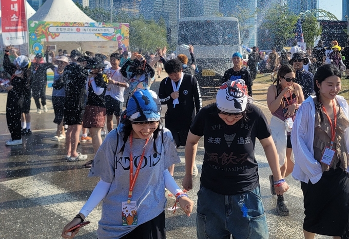 살수차에서 분수처럼 쏟아지는 물을 맞으며 즐거워하는 관객들 모습 ( 사진 = 이연수 기자 )