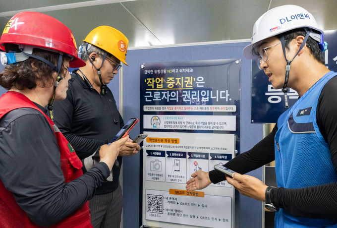 DL이앤씨 현장 안전관리자(오른쪽 첫 번째)가 현장 근로자들에게 안전신문고 접속 및 작업중지권 사용법에 대해 설명하고 있다. (사진=DL이앤씨 제공)