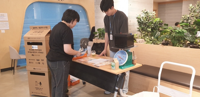 시청 직원이 폐자원을 종량제 봉투와 교환하는 모습. (사진=부천시 제공)